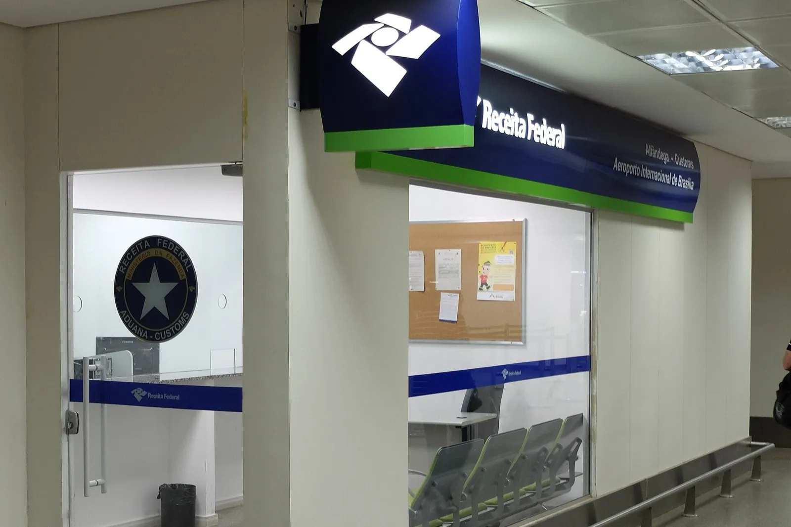 Posto da Receita Federal na alfândega do Aeroporto Internacional de Brasília, com letreiro azul e verde e selo da Receita Federal na porta.