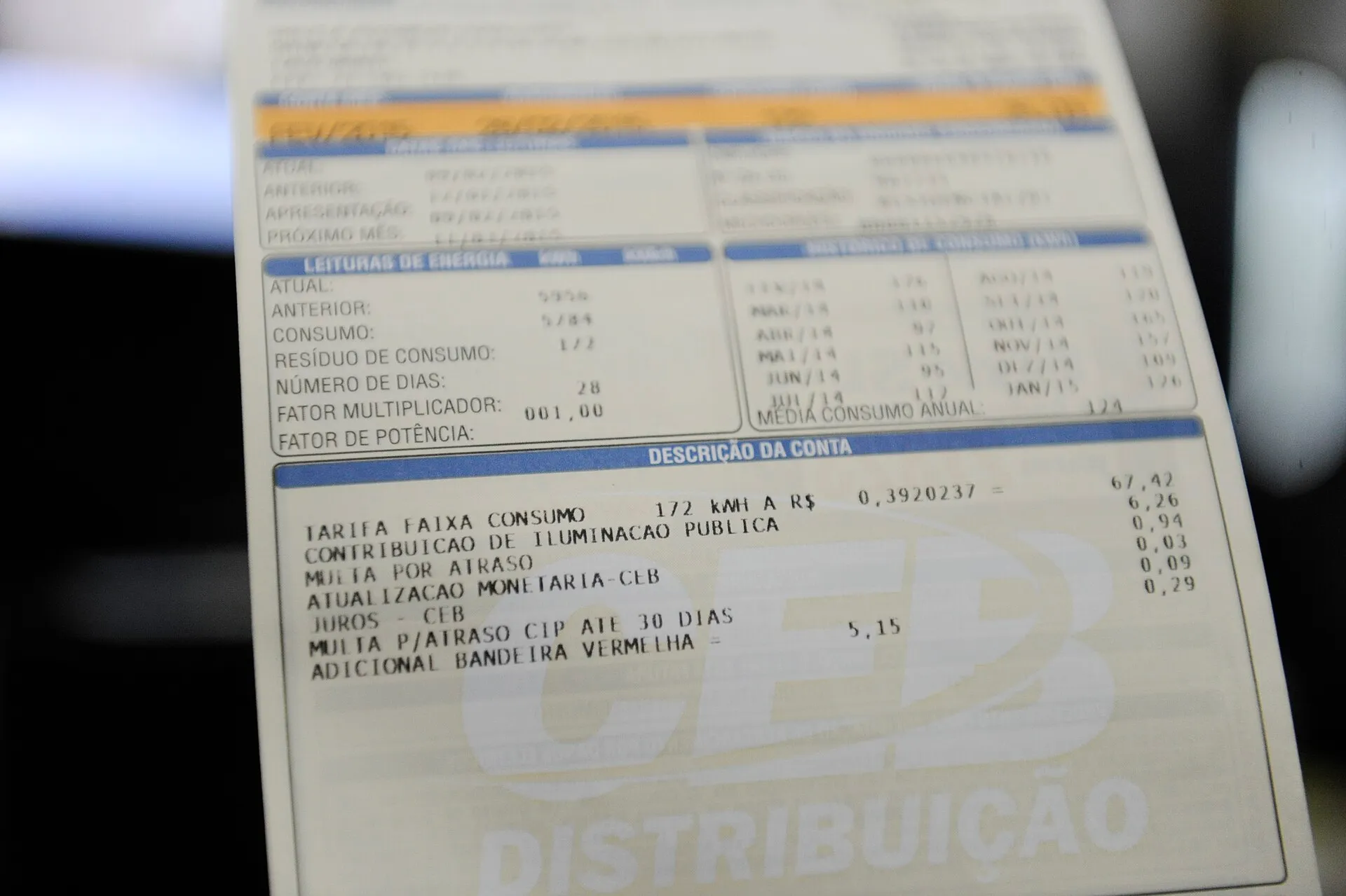 Conta de luz da CEB Distribuição, com a linha 'adicional bandeira vermelha' na descrição da conta, com valores em reais.