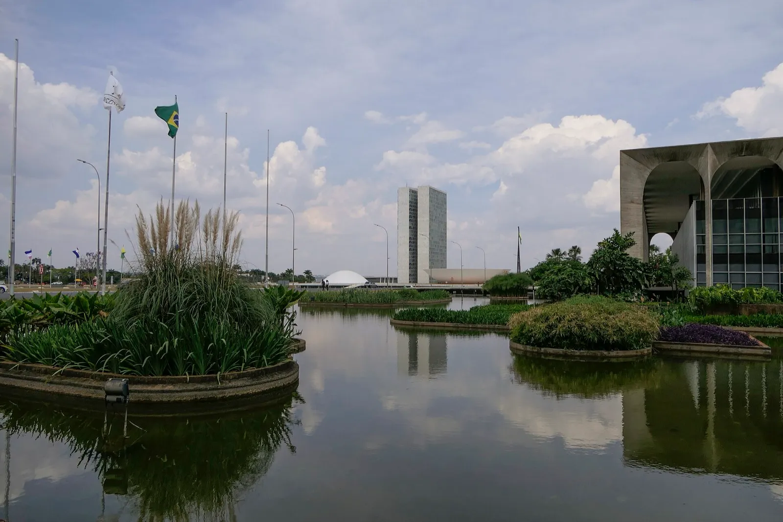 Espelho d'água com canteiros em Brasília; ao fundo, as duas torres e a cúpula branca do Congresso Nacional.