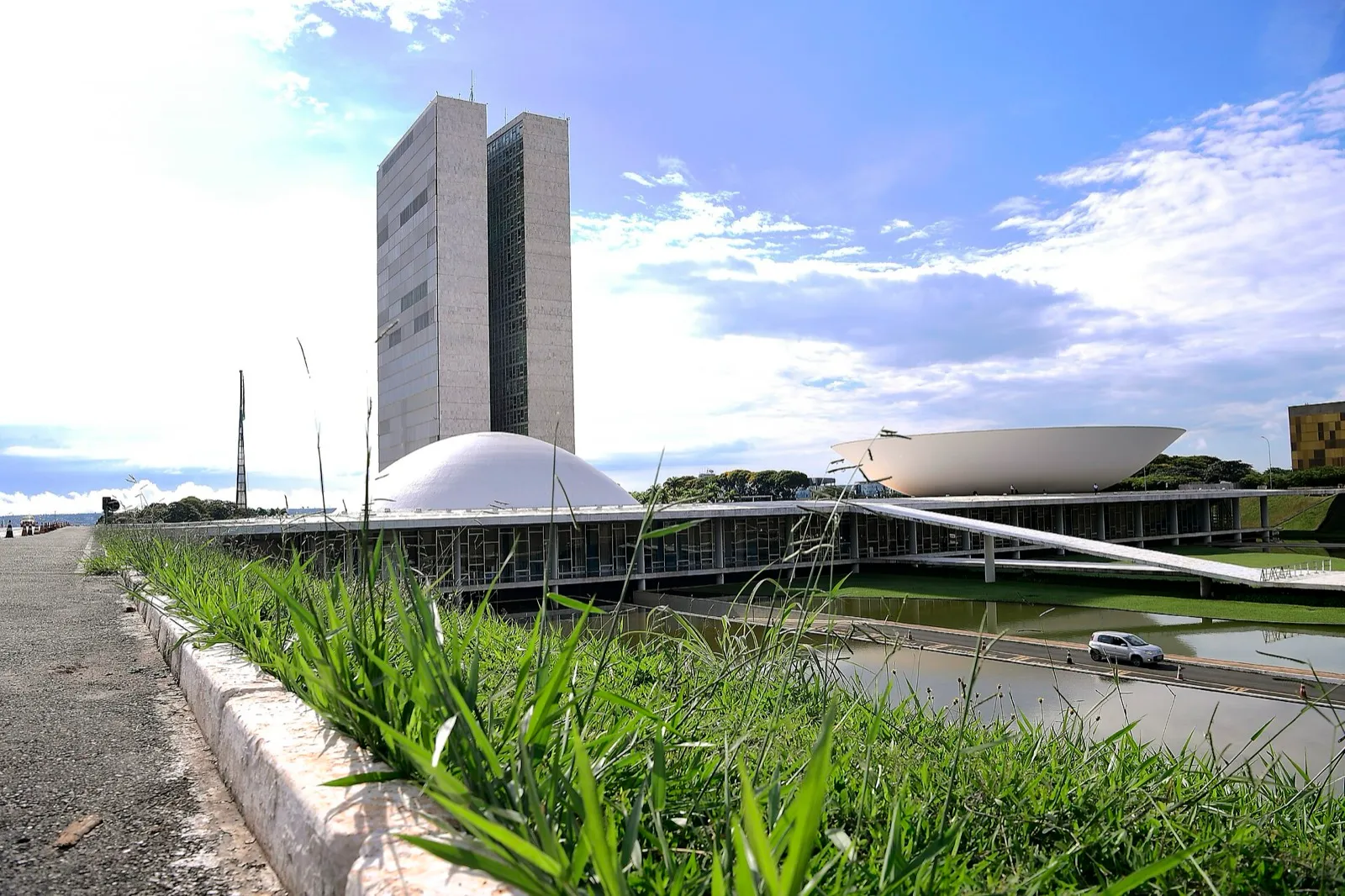 Fachada do Palácio do Congresso Nacional, em Brasília, com as duas torres e as cúpulas da Câmara e do Senado sob céu azul.