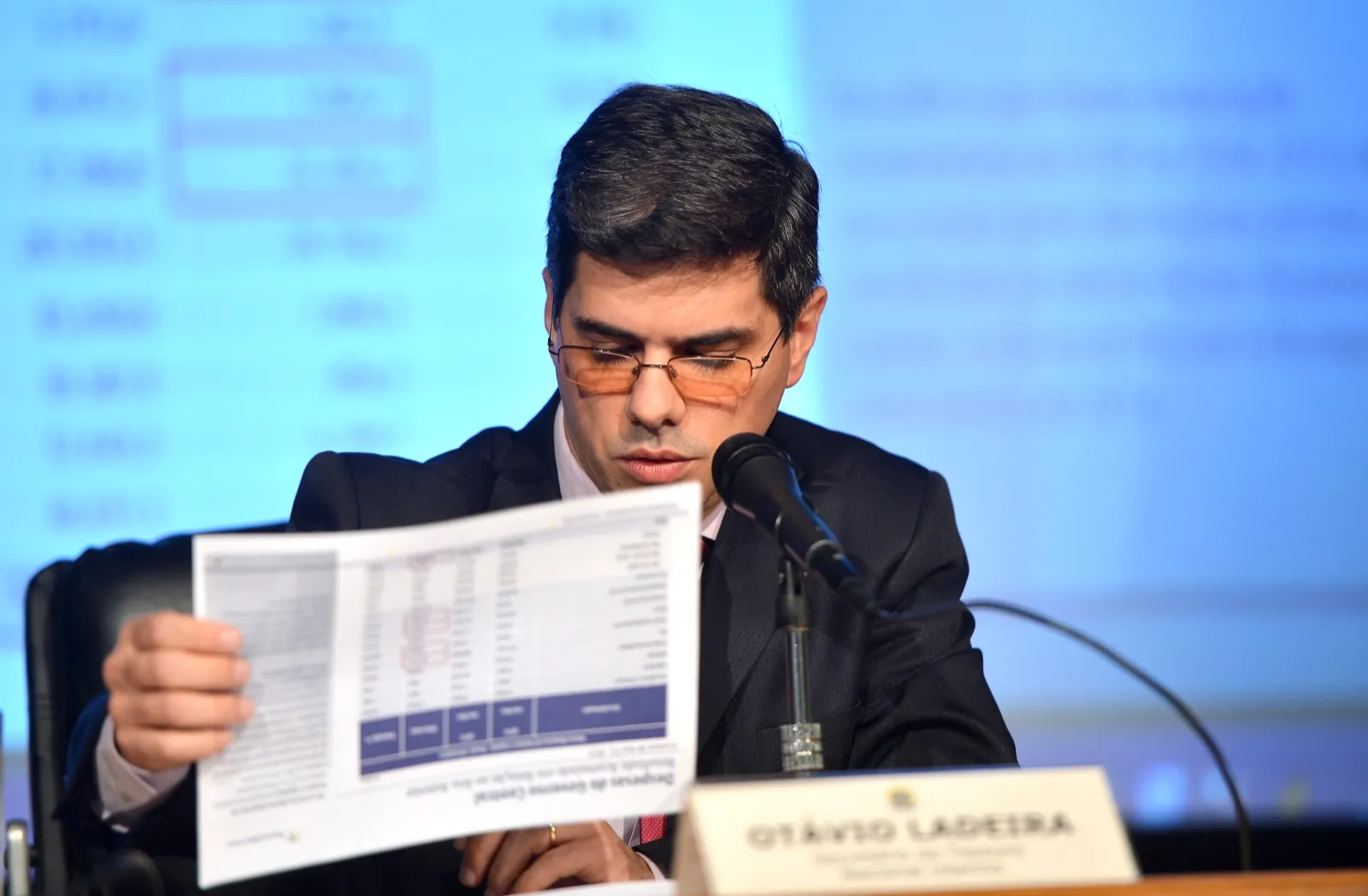Otávio Ladeira lê um documento diante de microfone durante coletiva do Tesouro Nacional